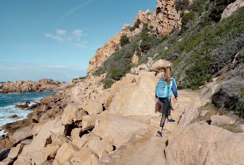 Italy, Sardinia, Santa Teresa Gallura Woman hiking along rocky coast. Santa Teresa Gallura, Sardinia, Italy.