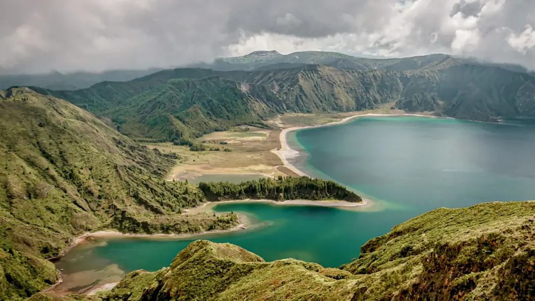 Grüne Berge mit Kratersee und Sandstränden. Sete Cidades, Azoren, Portugal.