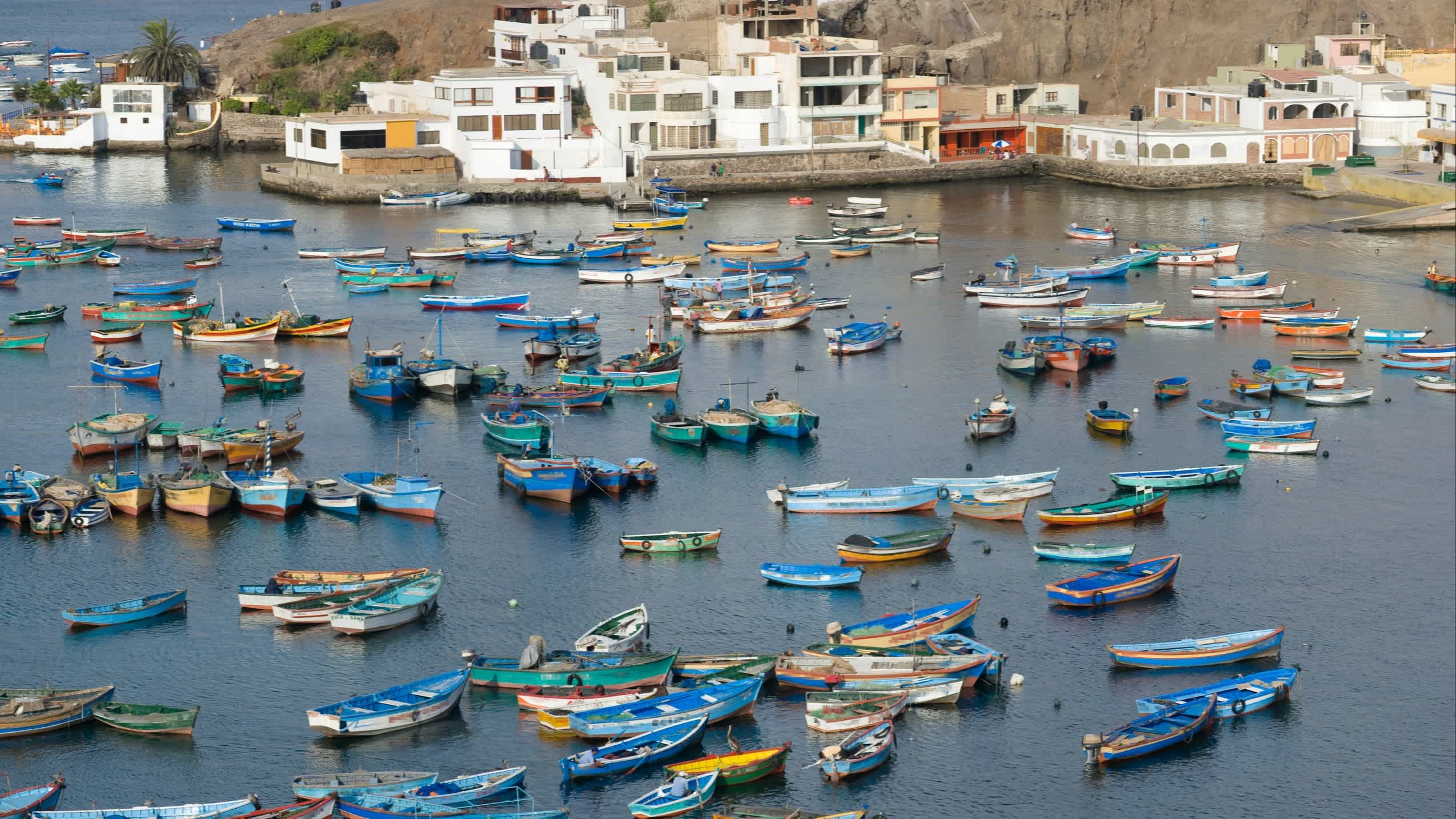 Luftaufnahme des Fischerdorfs Pucusana in Peru mit vielen bunten, traditionellen Booten im Wasser.