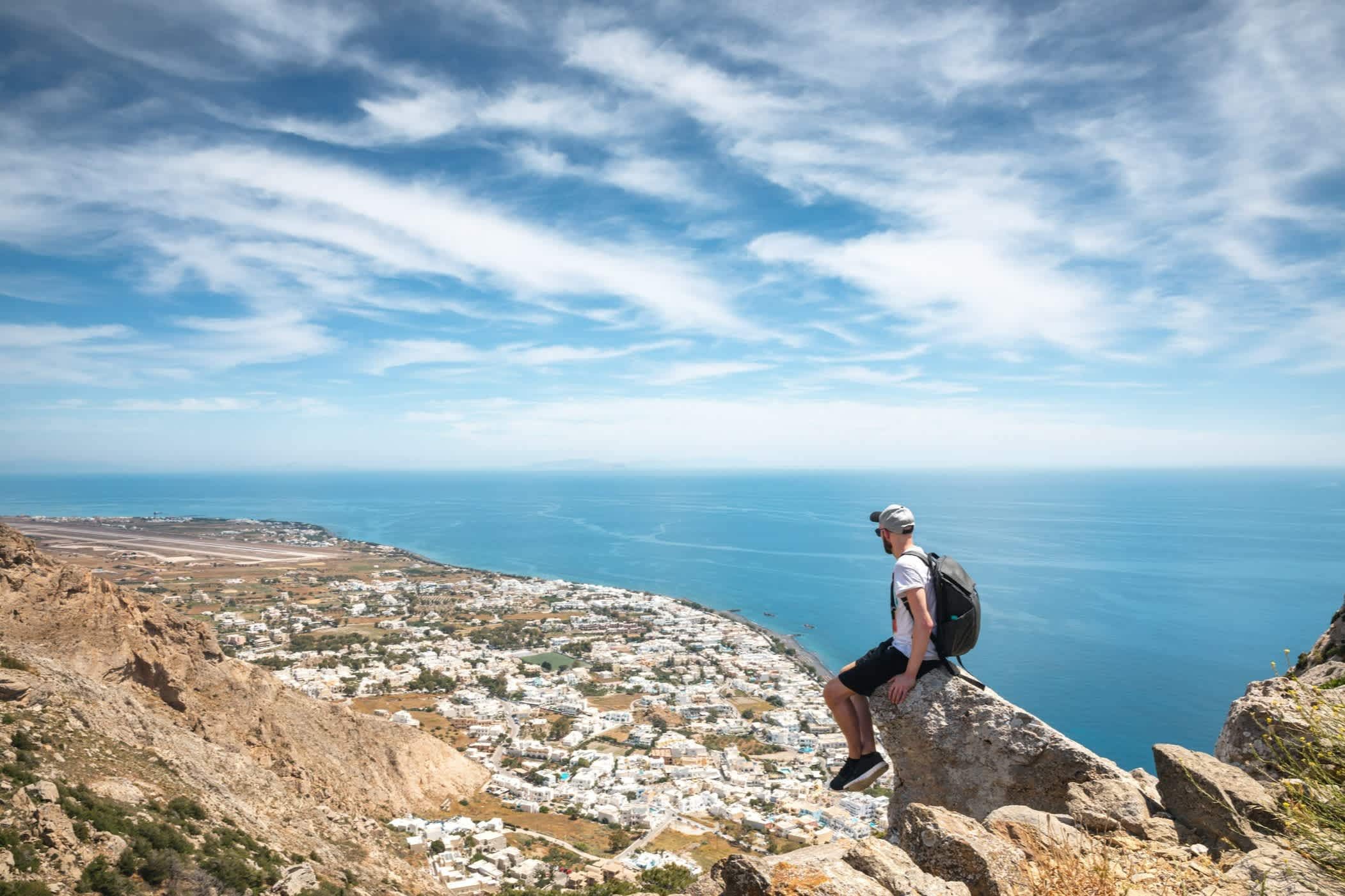 Mann am Aussichtspunkt mit Blick auf die Küste von Santorini