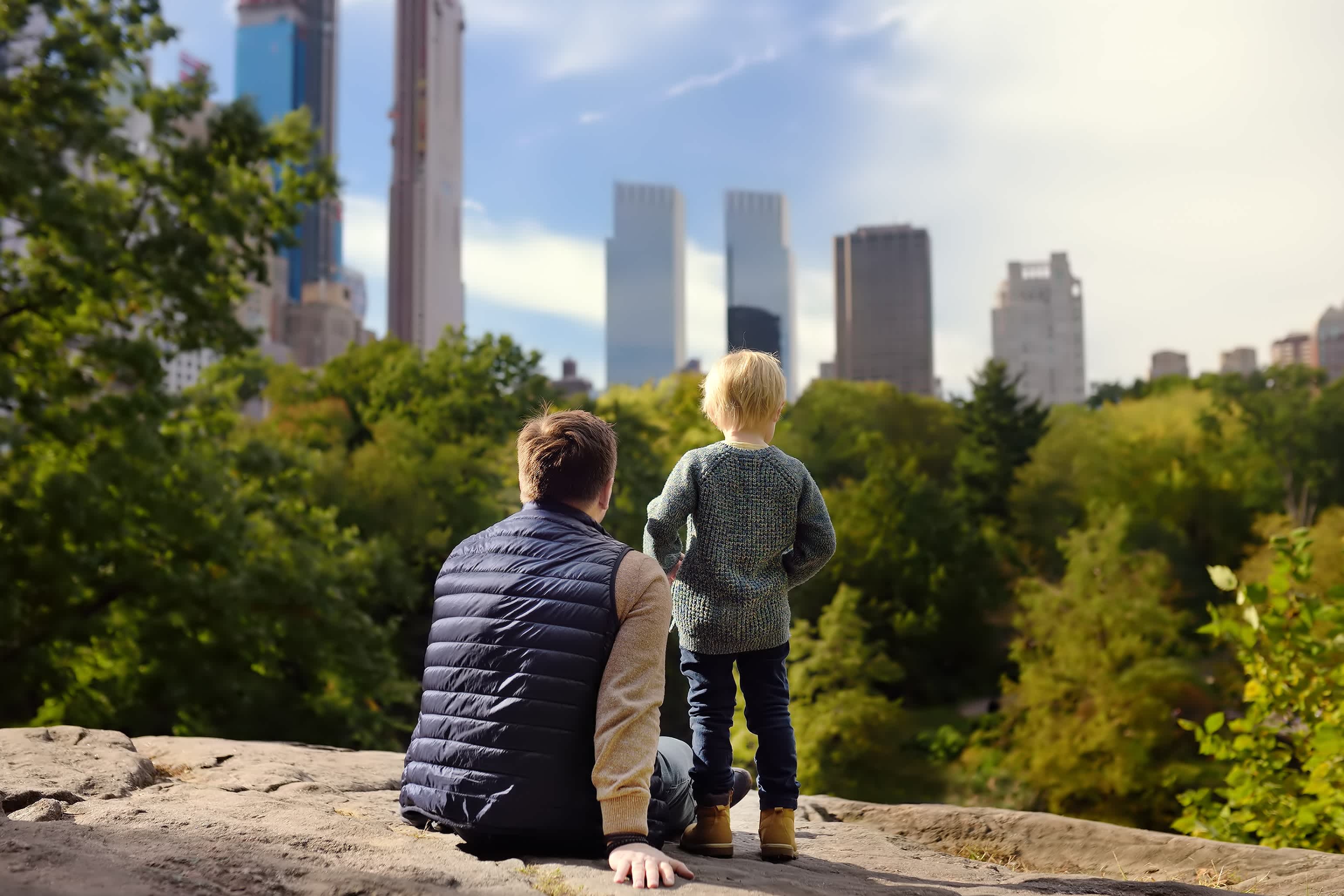 Vater und Sohn im Central Park betrachten die New Yorker Skyline