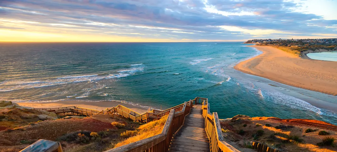 Blick auf einen Steg, der zu einem Strand führt, Sonnenuntergang, Australien