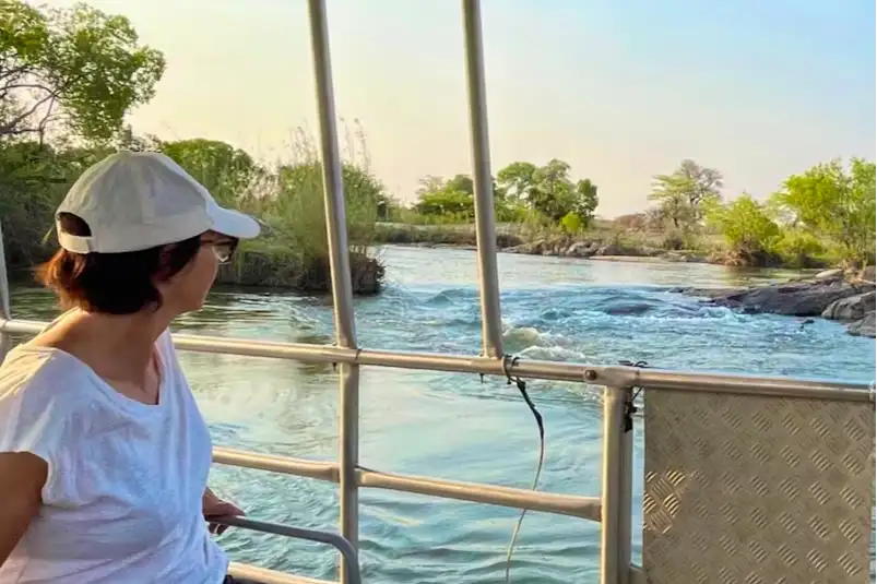 Namibie, fleuve Okavango, croisière Une femme dans un bateau lors d'une croisière au coucher du soleil, fleuve Okavango, Namibie.