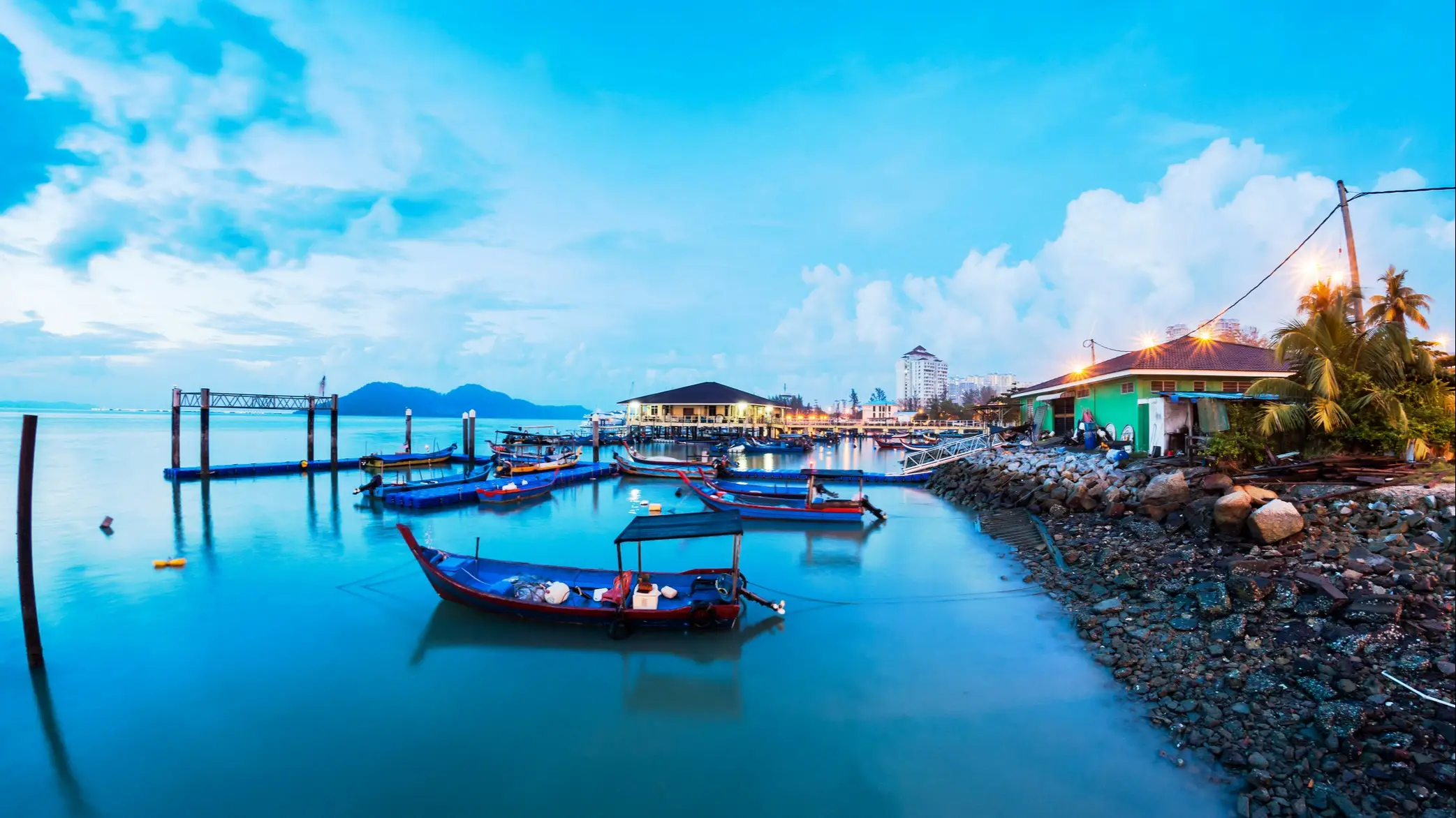 Bunte Fischerboote am ruhigen Hafen bei Dämmerung, Pulau Penang, Malaysia.