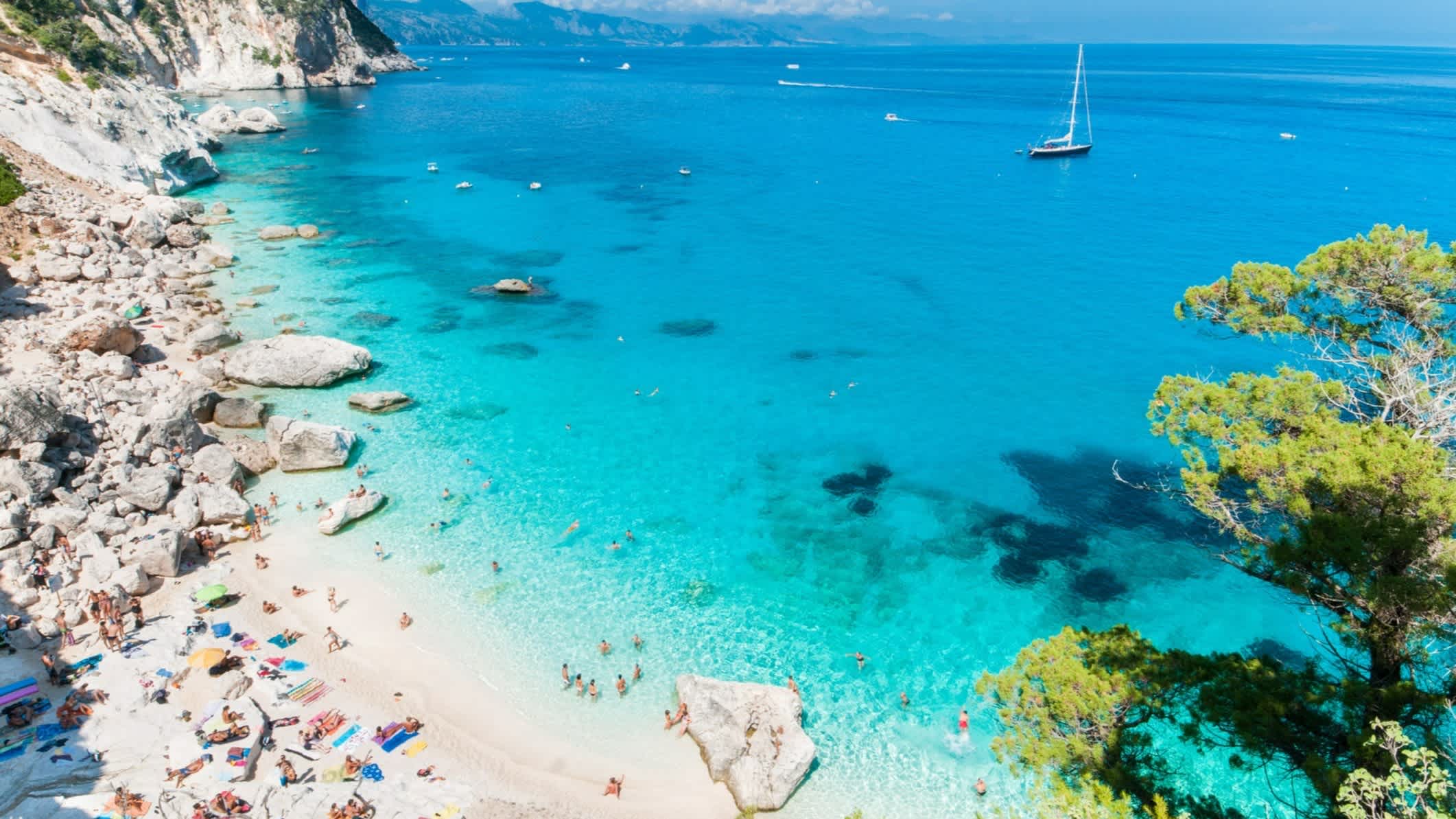 Ein Blick von oben auf den Strand von Cala Goloritzè, Sardinien, Italien mit einem Segelboot im türkisen Wasser.