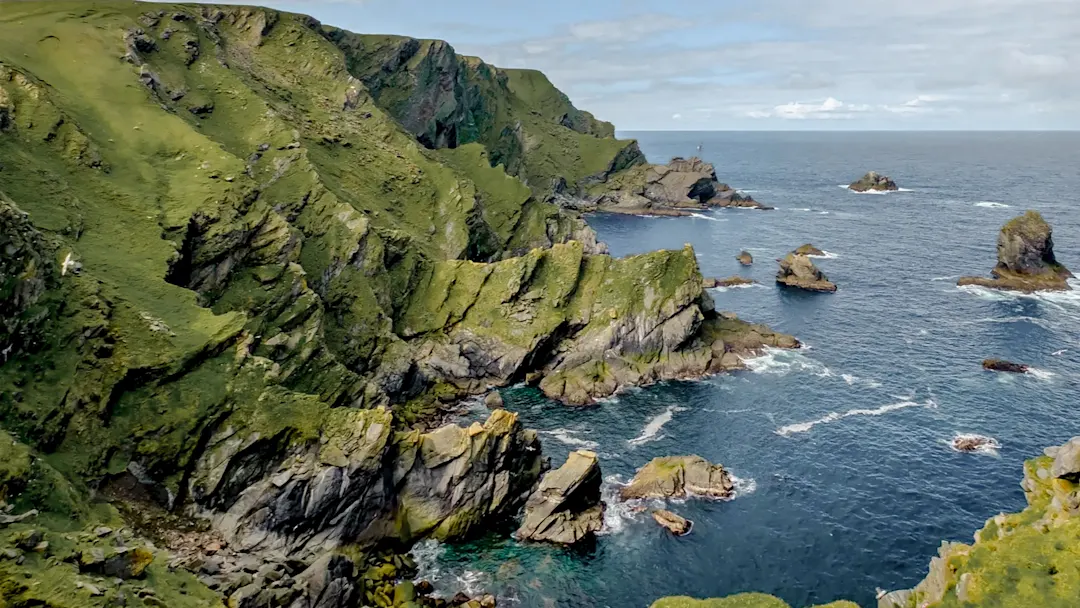Steilküste mit grünen Hügeln und Klippen. Eshaness, Shetland, Schottland.