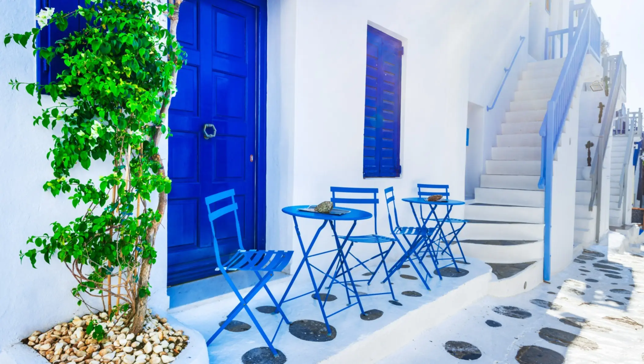 Mobilier de jardin bleus devant une façade blanche typique, quartier de la vieille ville, à Mykonos, en Grèce