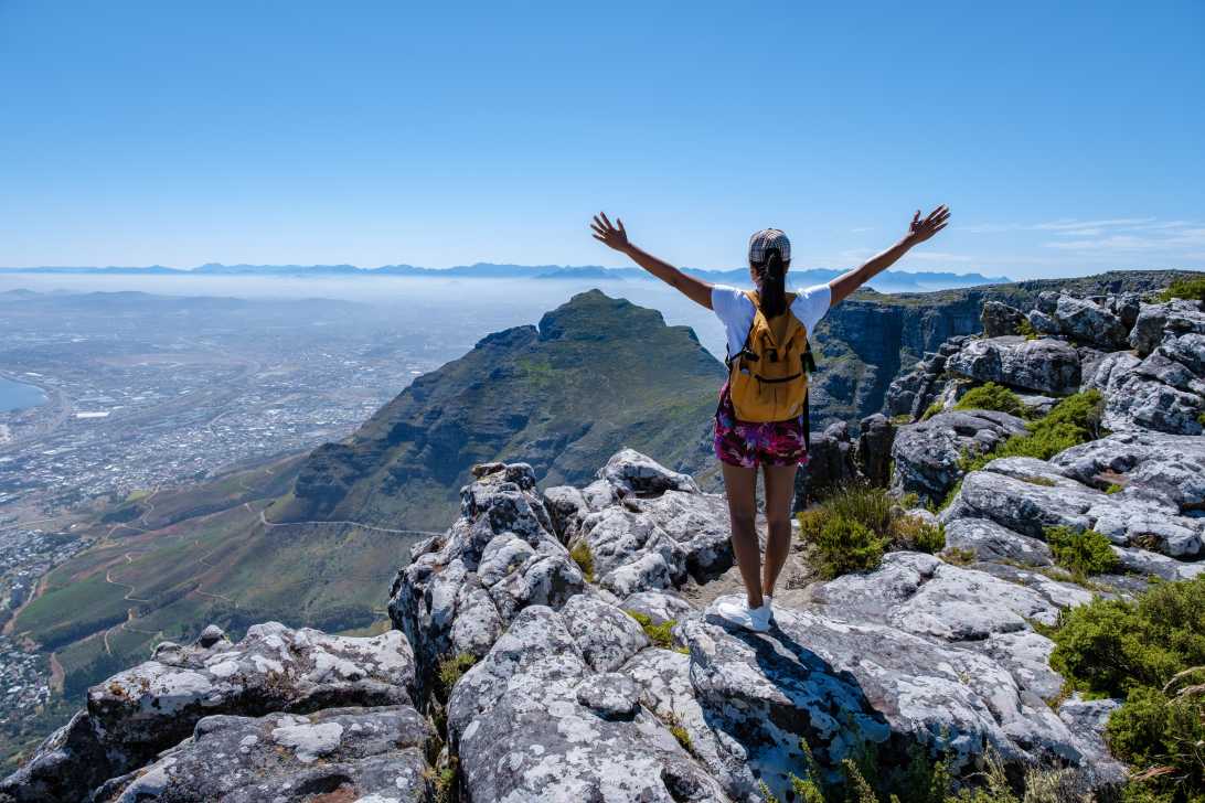 Frau steht auf dem Tafelberg in Südafrika bei Sonnenschein in Kapstadt. 
