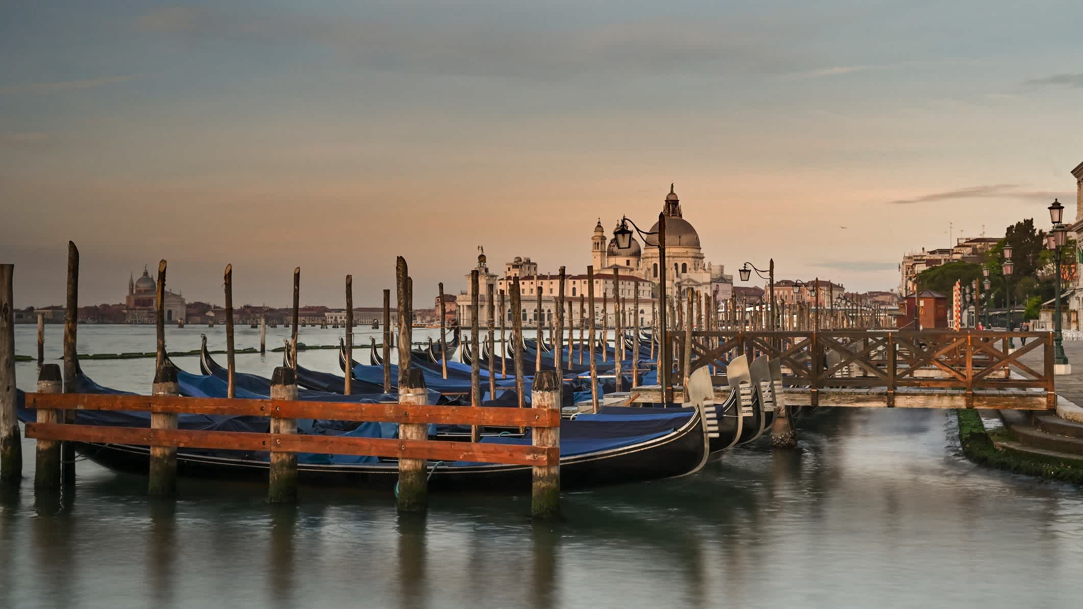 Le coucher de soleil sur la promenade de la Riva degli Schiavoni avec les gondoles, à Venise, Italie.
