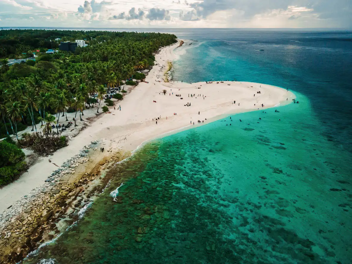 Les Maldives, avec une plage et l'horizon sous un ciel nuageux. Vue aérienne de la côte océanique à Fuvahmulah