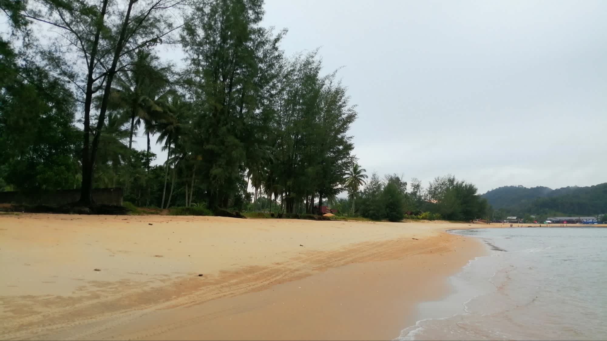 Langer Sandstrand des Cherating Beach, Pahang, Malaysia bei bewölktem Himmel.