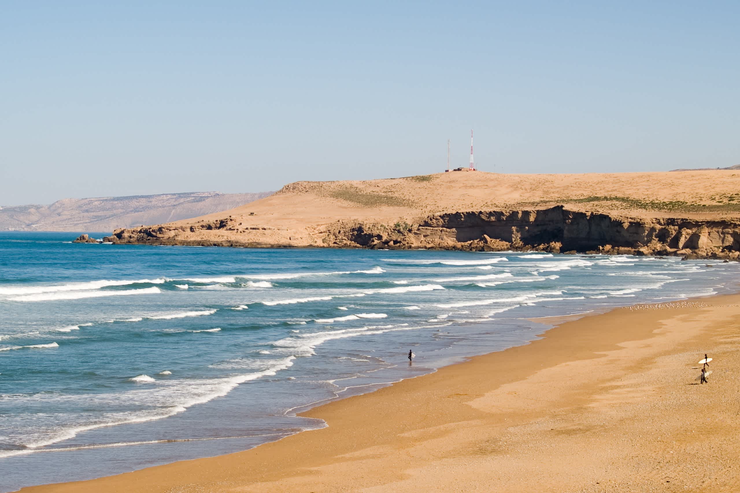Surfeurs sur l'immense plage de sable du Maroc