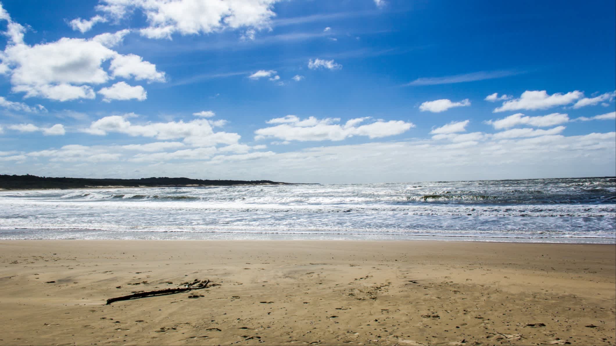 Strand in Punta Del Diablo, Uruguay bei blauem Himmel.