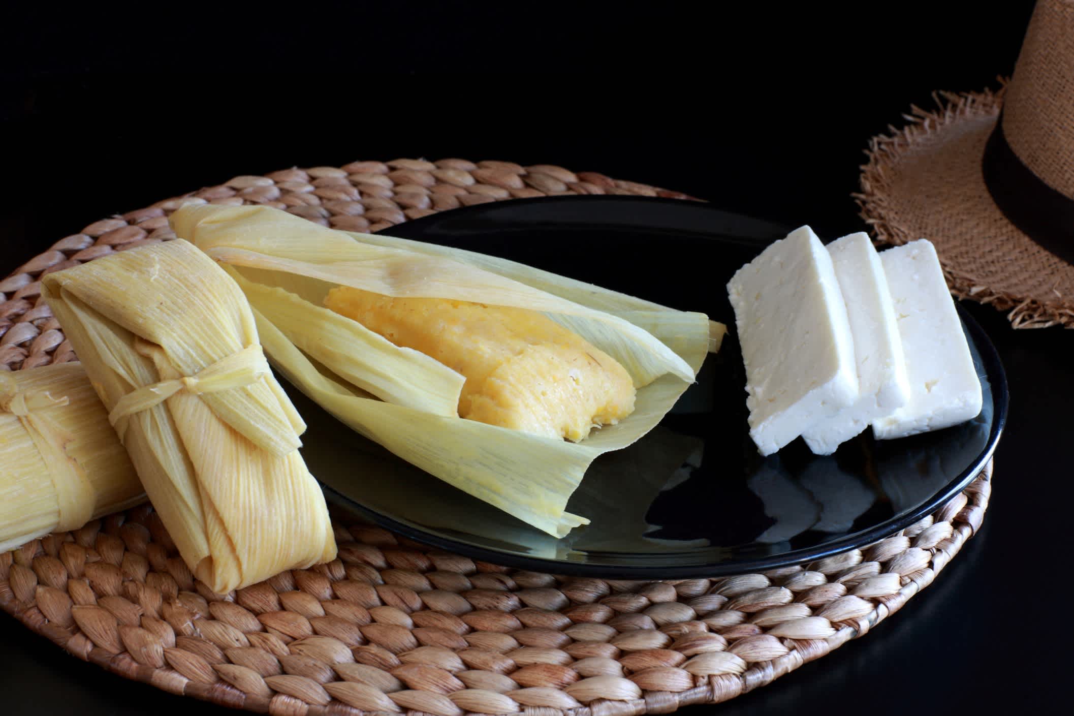Humita - lateinamerikanischen traditionelle Speisen. Mais und Blätter mit Käse serviert
