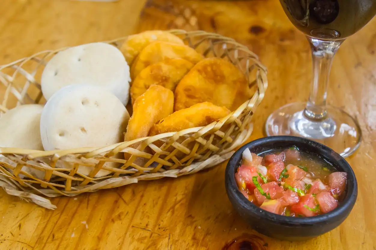 Chile, Pan Amasado con Pebre Lateinamerikanisches Essen. Traditionelle chilenische hausgemachte Kürbis-Sopaipillas mit Salsa und traditionellem Brot "Hallullas".