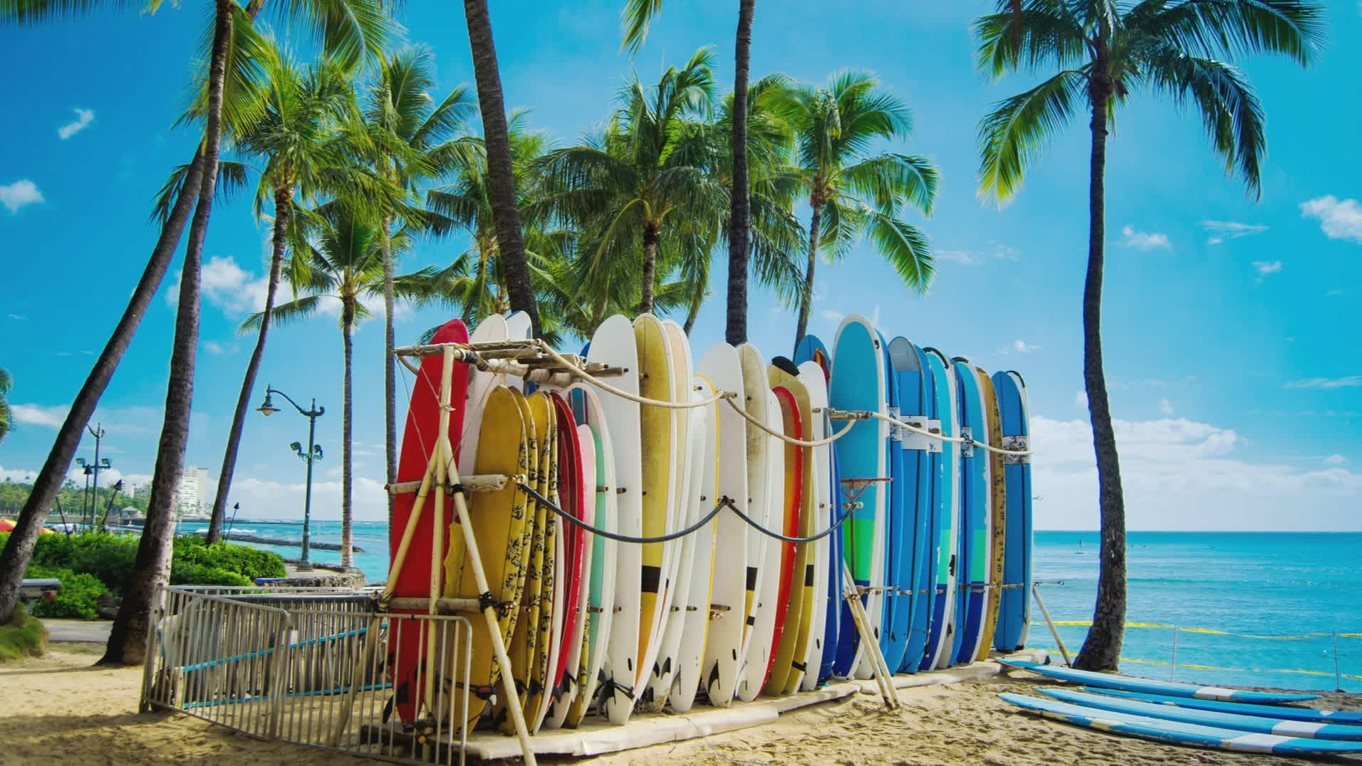 Surfbretter am berühmten Waikiki-Strand, Honolulu, Hawaii, USA bei klarem sonnigem Blick auf das Meer.