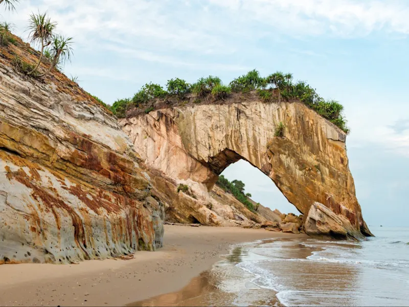 Plage avec formations rocheuses, Malaisie L'île de Perhentian offre des plages idylliques et des eaux cristallines, mais aussi des formations rocheuses qui rappellent les arches d'une tour.