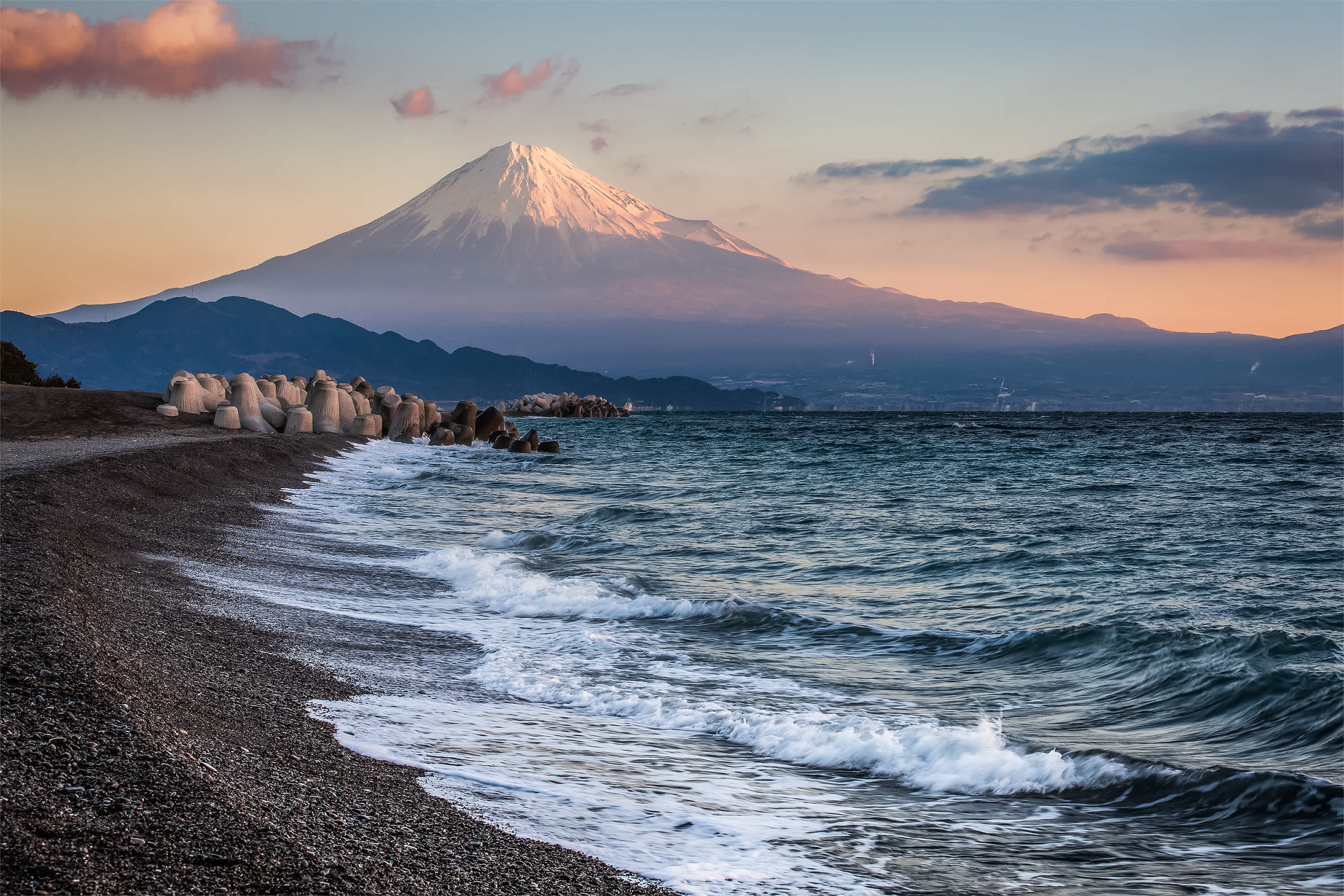 Plage sombre au bord de la mer avec le Mont Fuji en arrière-plan, au Japon