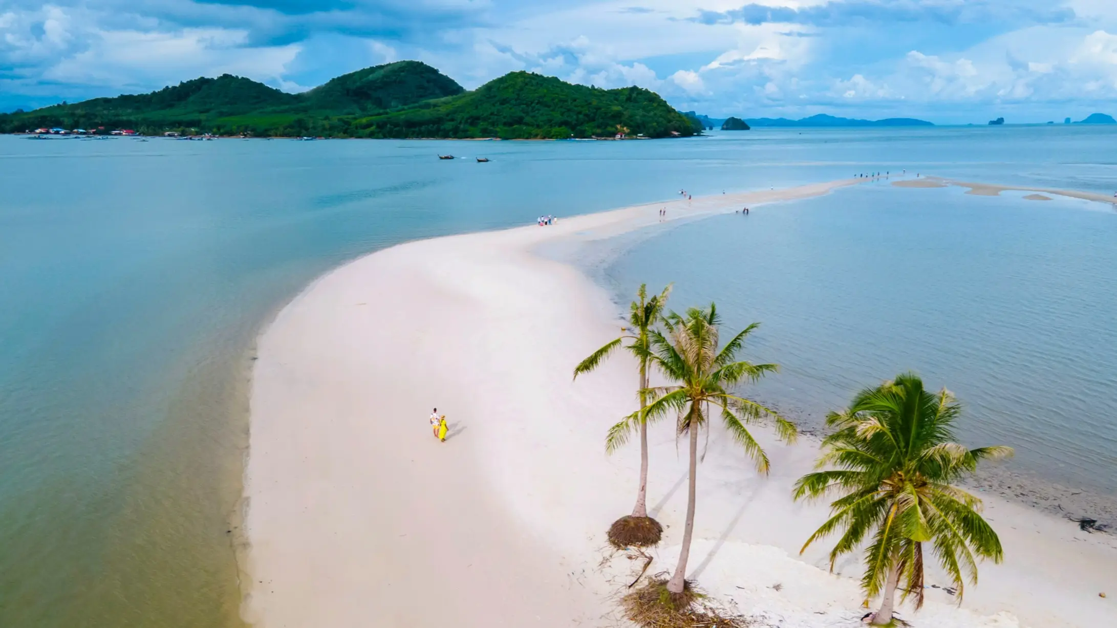 Sandige Landzunge gesäumt von Palmen mit grünen Hügeln im Hintergrund, Koh Yao Noi, Thailand. 