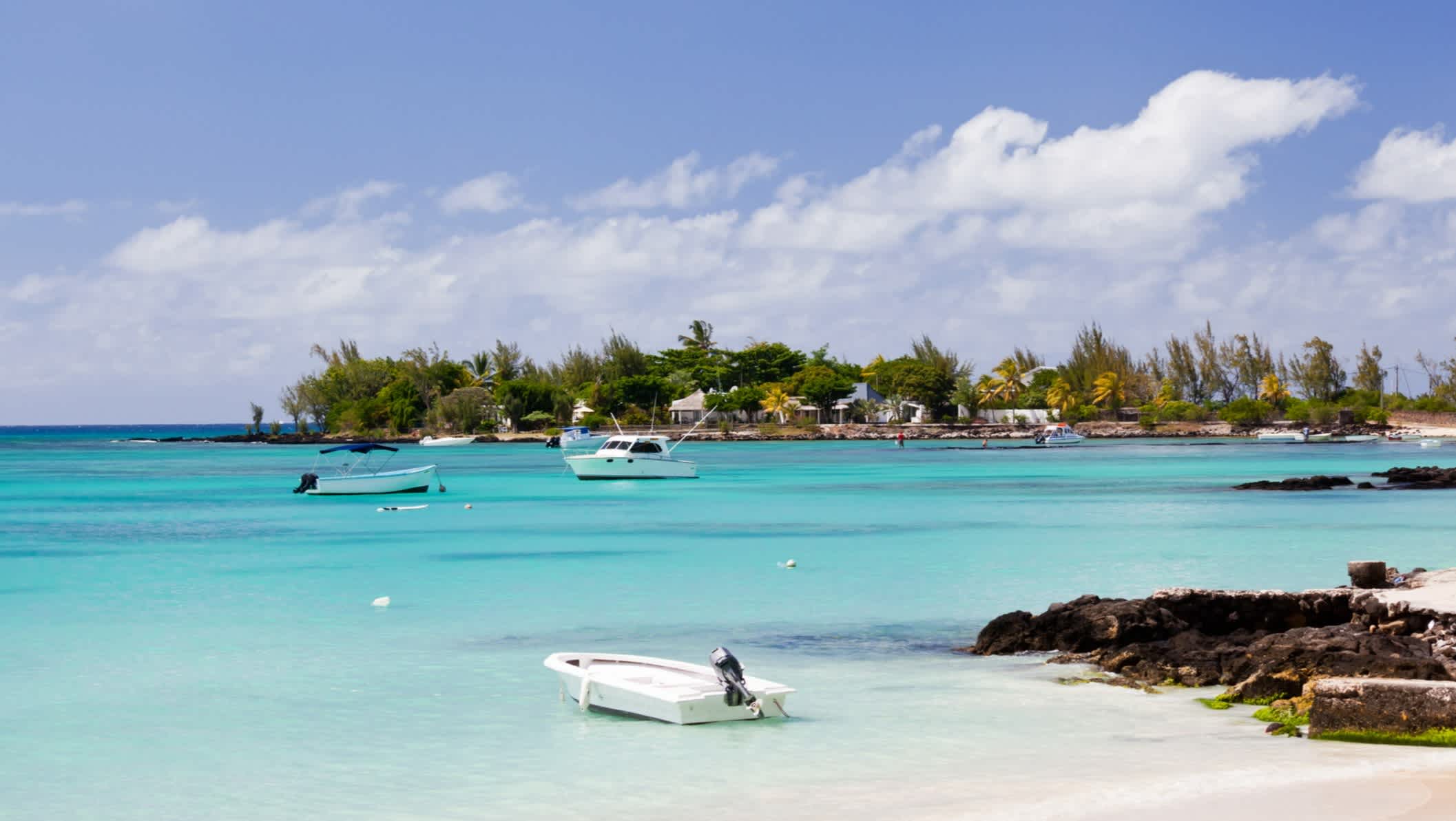 Bateaux sur l'eau turquoise au bord de la plage de sable blanc de Pereybere, Ile Maurice 