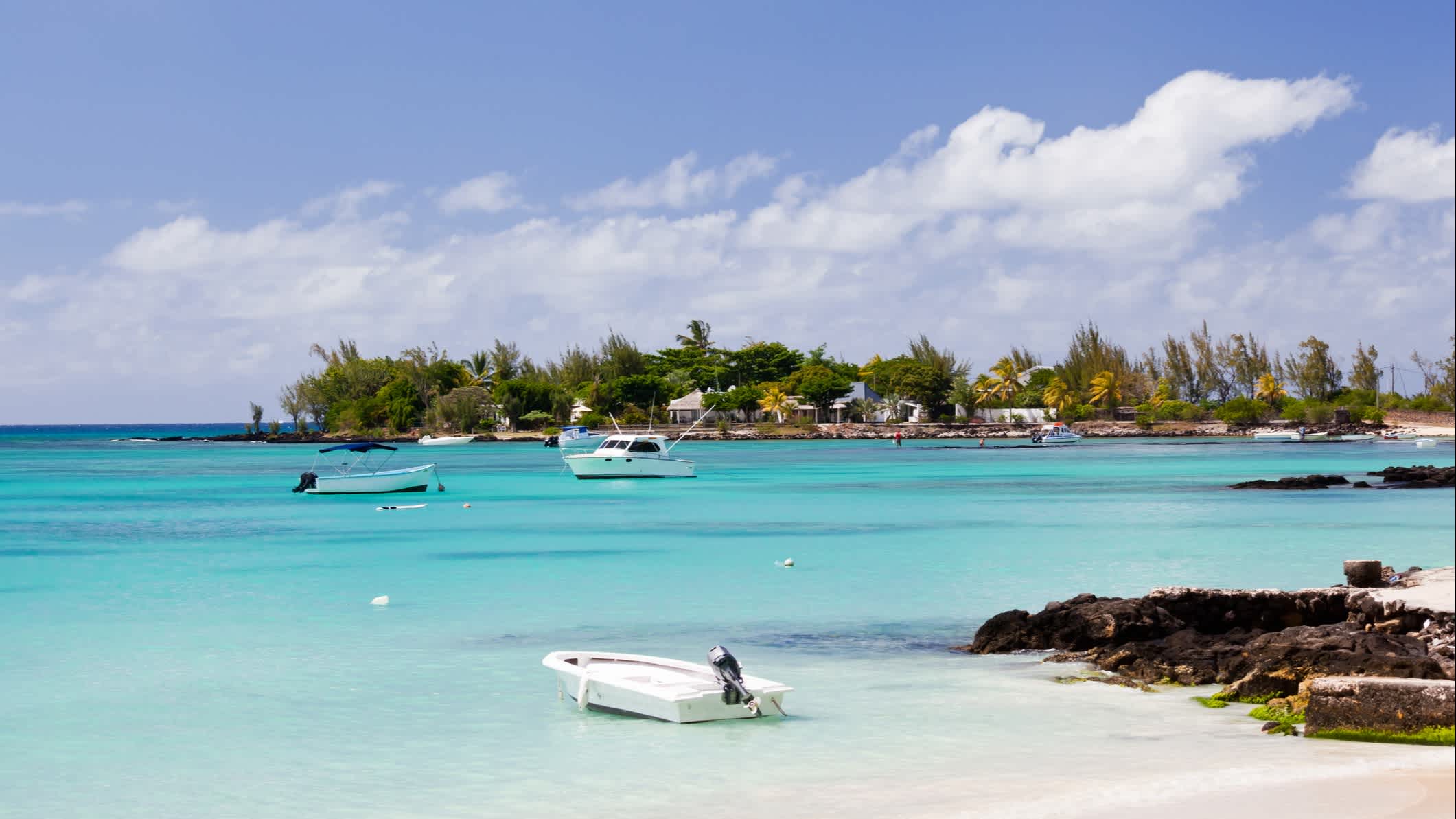 Bateaux sur l'eau turquoise au bord de la plage de sable blanc de Pereybere, Ile Maurice 