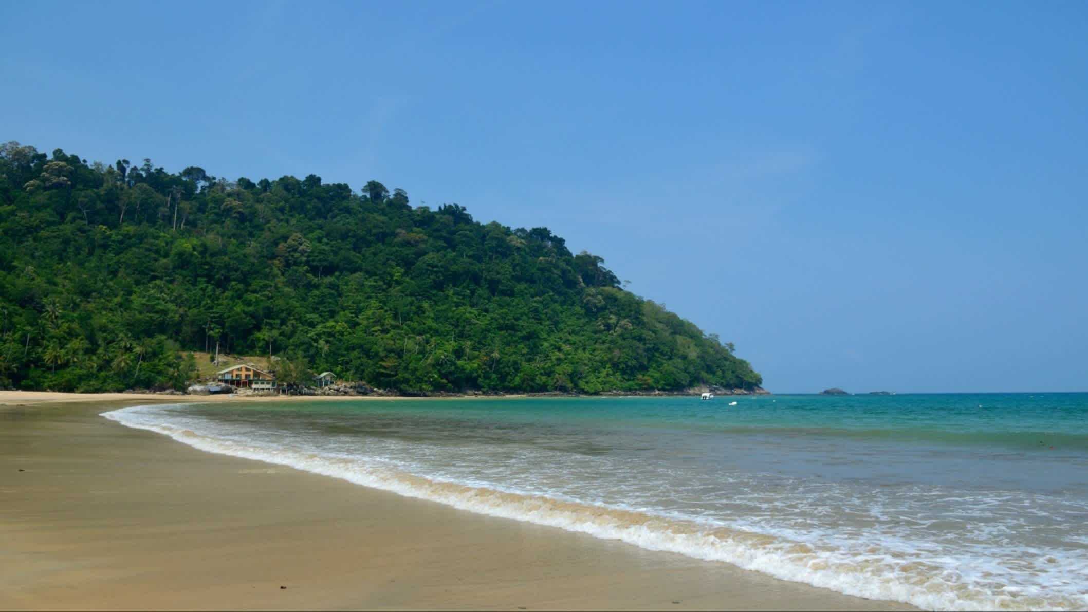 Flach abfallender Sandstrand Juara Beach, Tioman, Malaysia mit Blick über den Strand, das seichte Türkisen Meer sowie Vegetation.