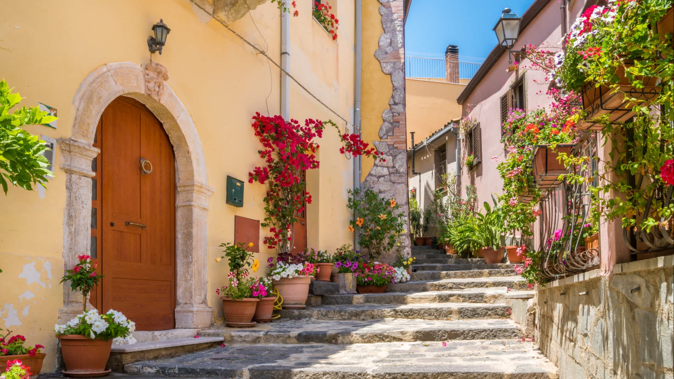Vue sur une ruelle pavée avec des escaliers et des bâtiments colorés à Messine, Sicile, Italie
