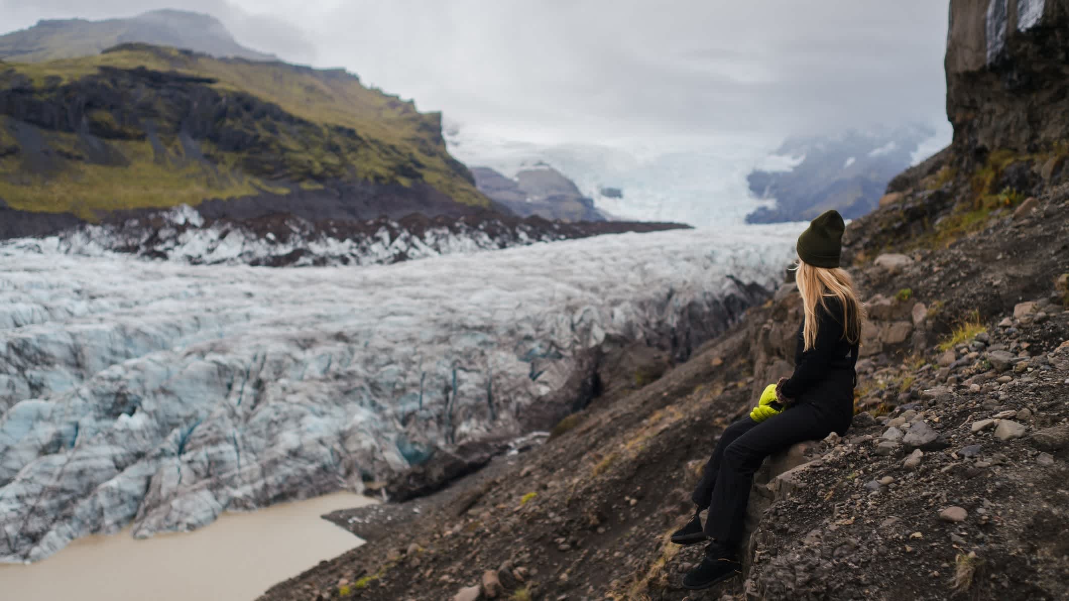 Une touriste observe un glacier en Islande