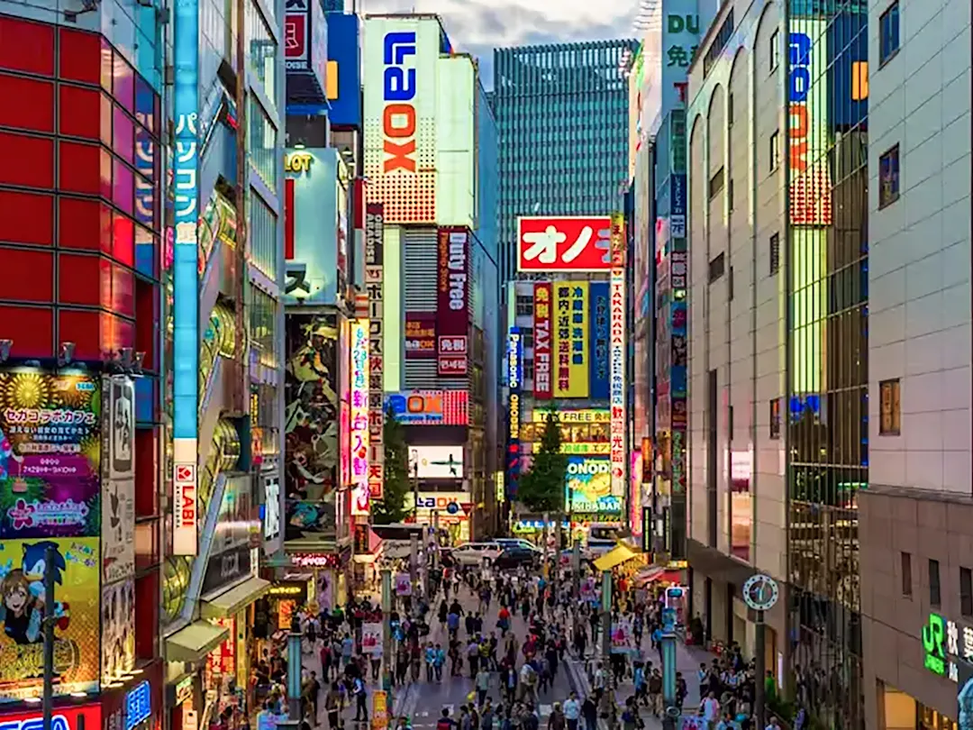 Ein geschäftiger Stadtteil mit Neonlichtern und belebten Straßen in Tokio, Japan.