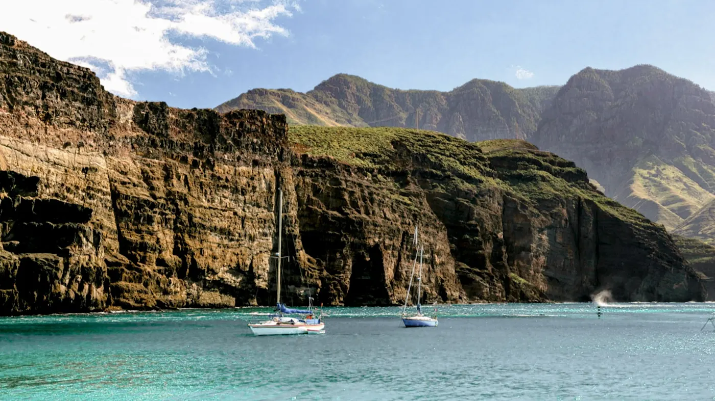 Steilküste und Segelboote im türkisfarbenen Wasser. Los Gigantes, Teneriffa, Spanien.
