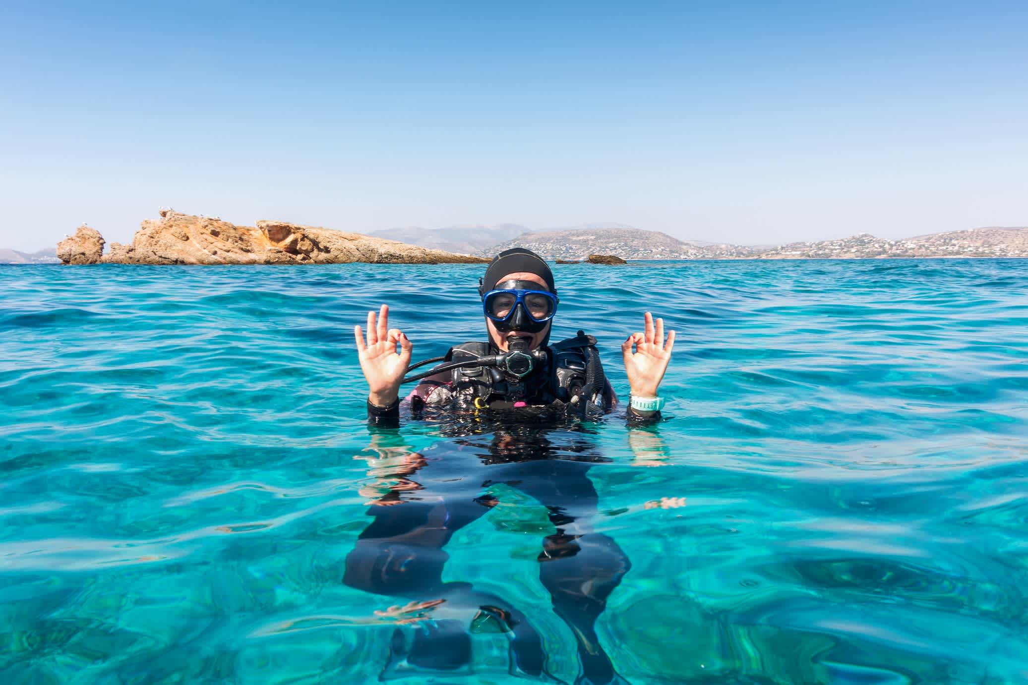 Grèce, une plongeuse dans une eau turquoise.