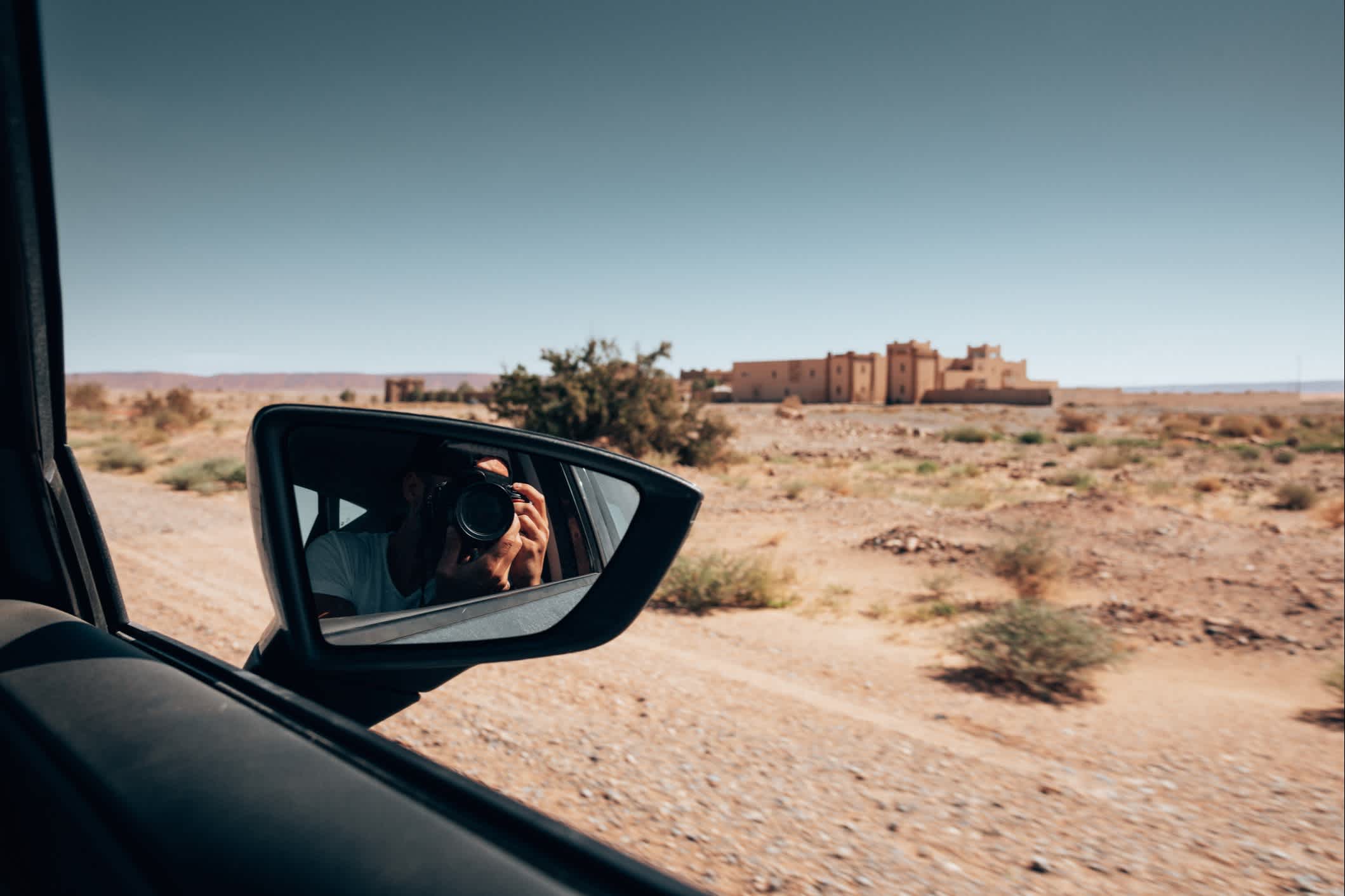 Frau fährt mit dem Auto durch Marokko und macht Fotos