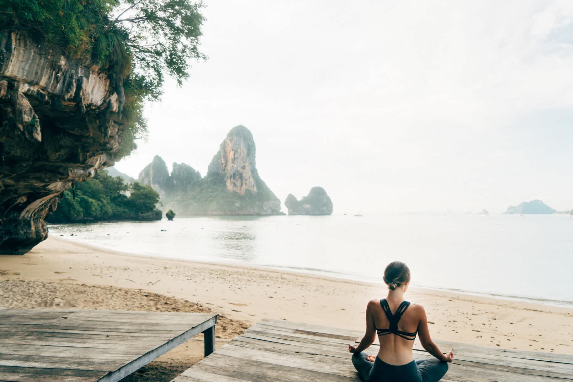 Femme faisant du yoga sur la plage en Thaïlande

