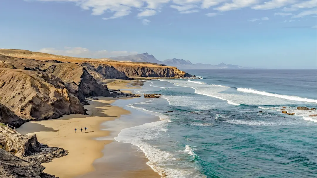 Wilde Küste mit Sandstrand und felsigen Klippen. Spanien, Kanaren, Fuerteventura