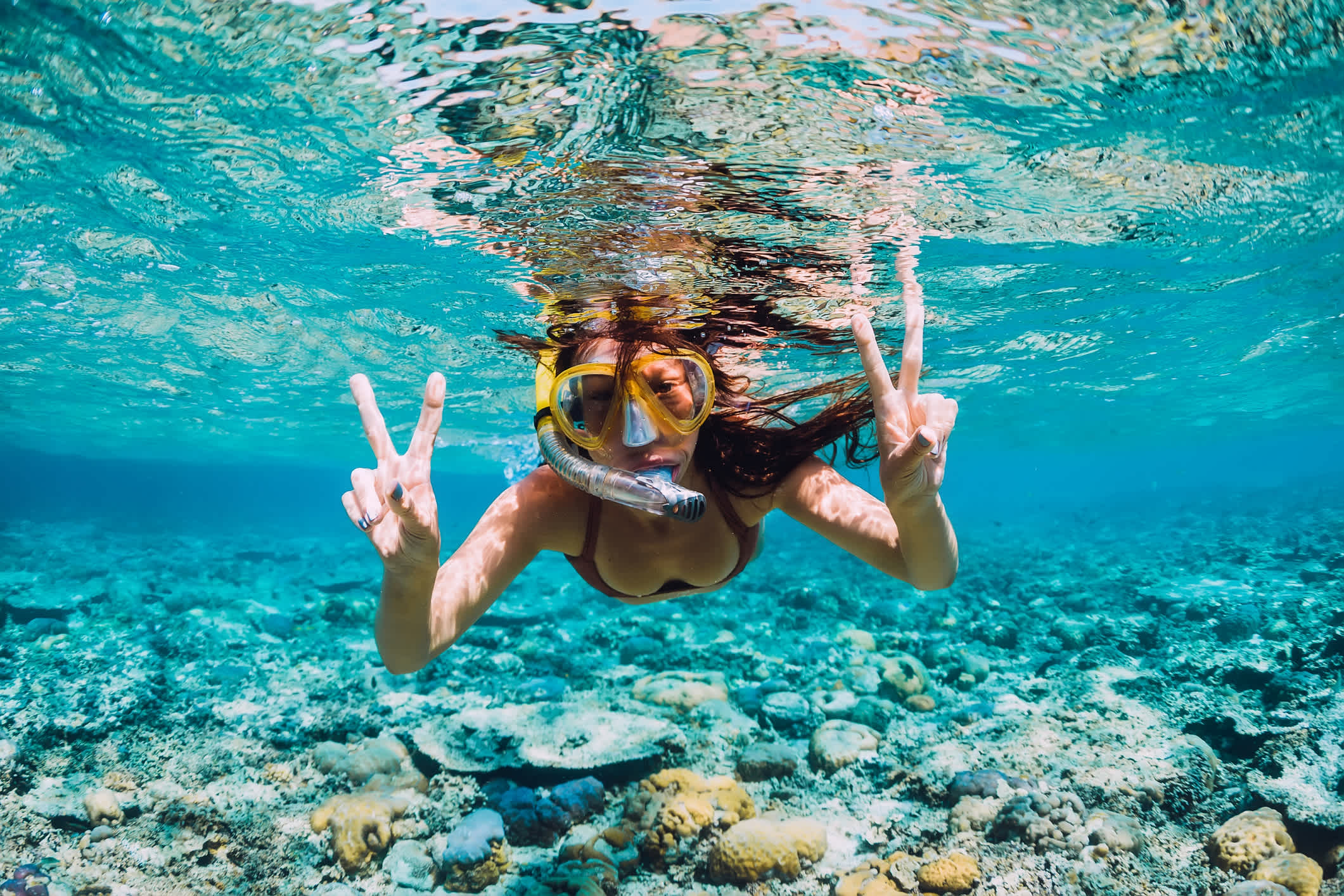 Glückliche junge Frau taucht im tropischen Ozean.