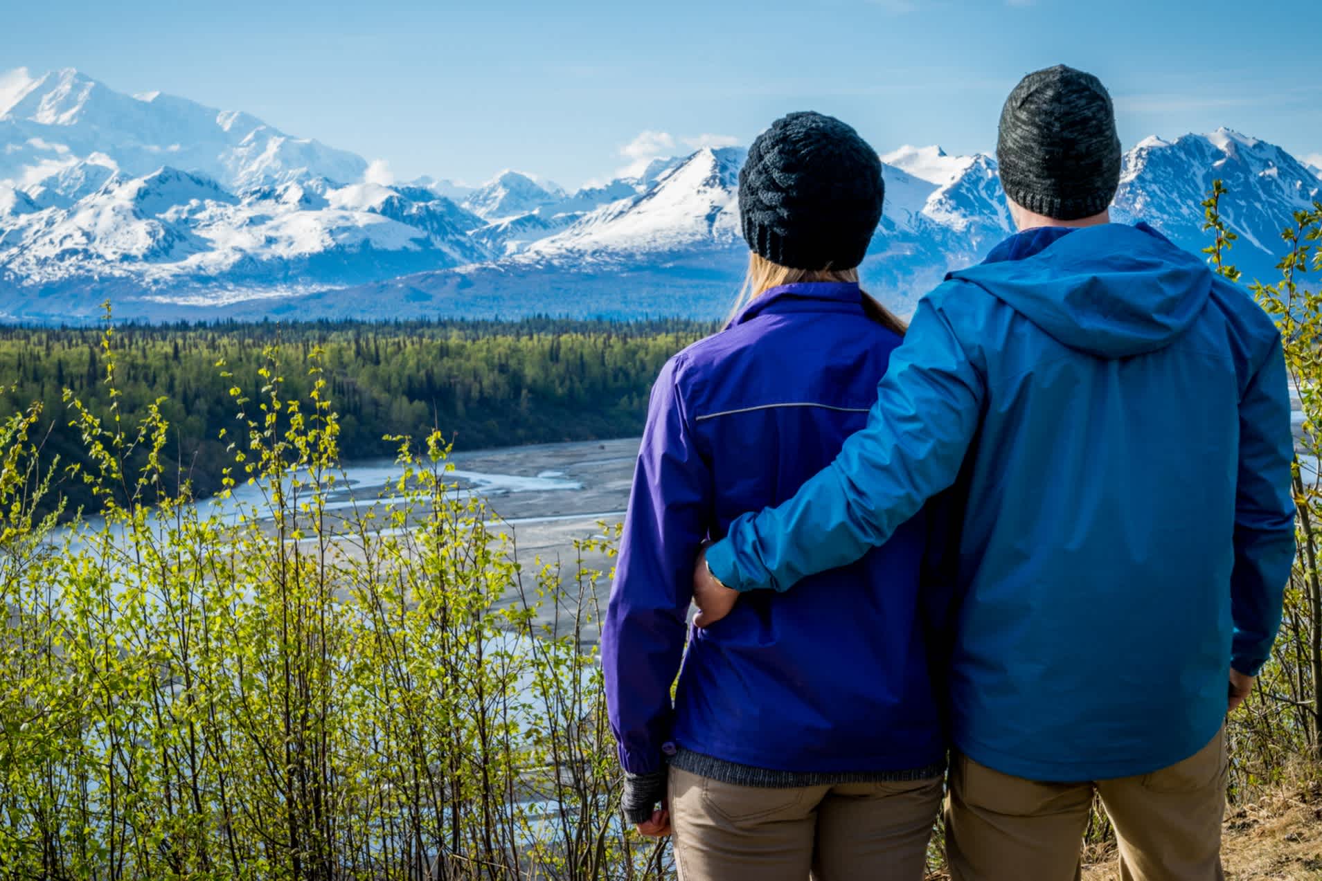 Junges Paar hält sich gegenseitig und steht vor Mount Denali früher Mount Mckinley, Alaska.