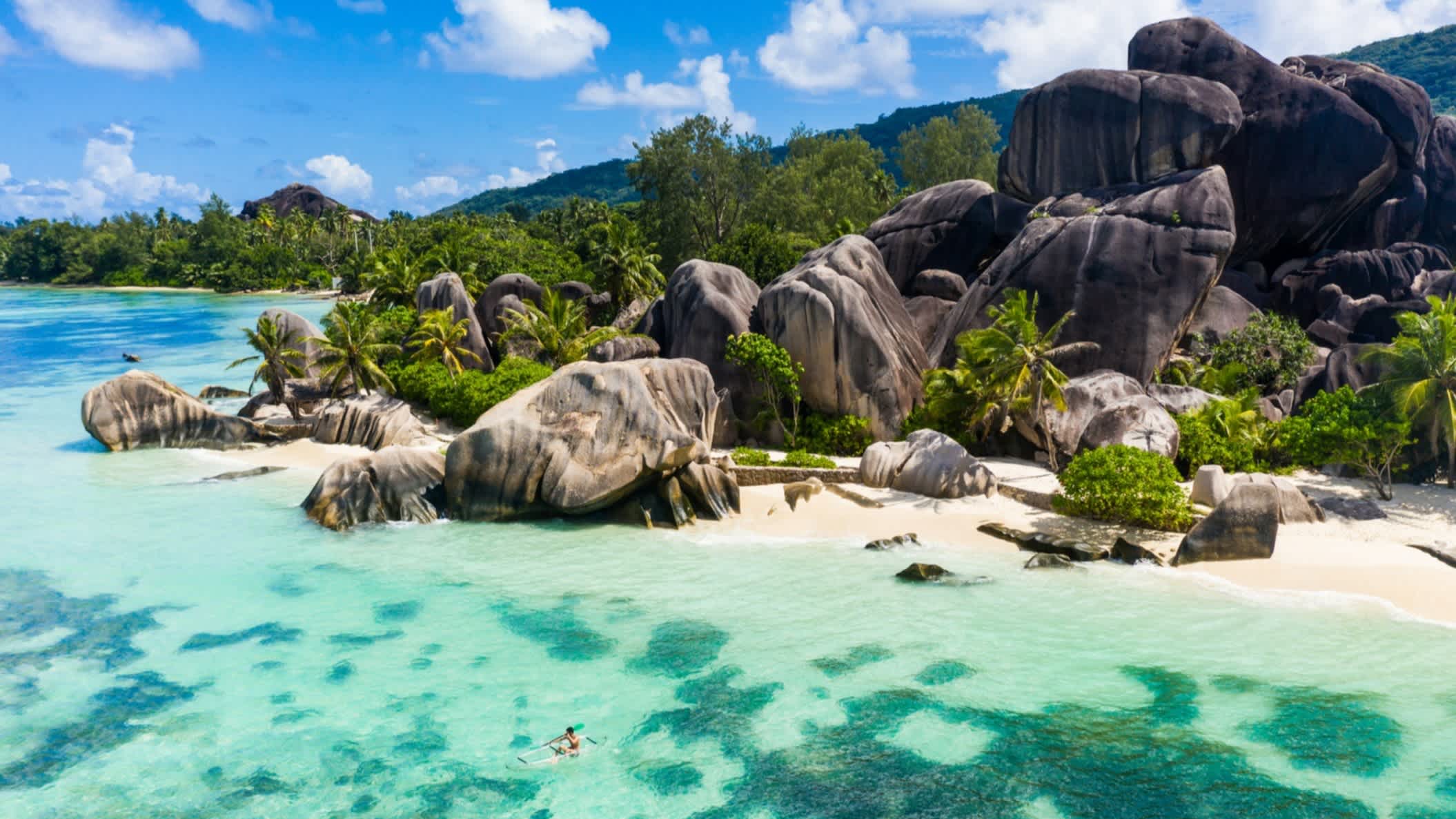 Die Anse Source D'Argent, Strand mit weißem Sand und riesigen Granitfelsen mit vorgelagertem Riff aus der Luft aufgenommen, auf der Insel La Digue, Seychellen.