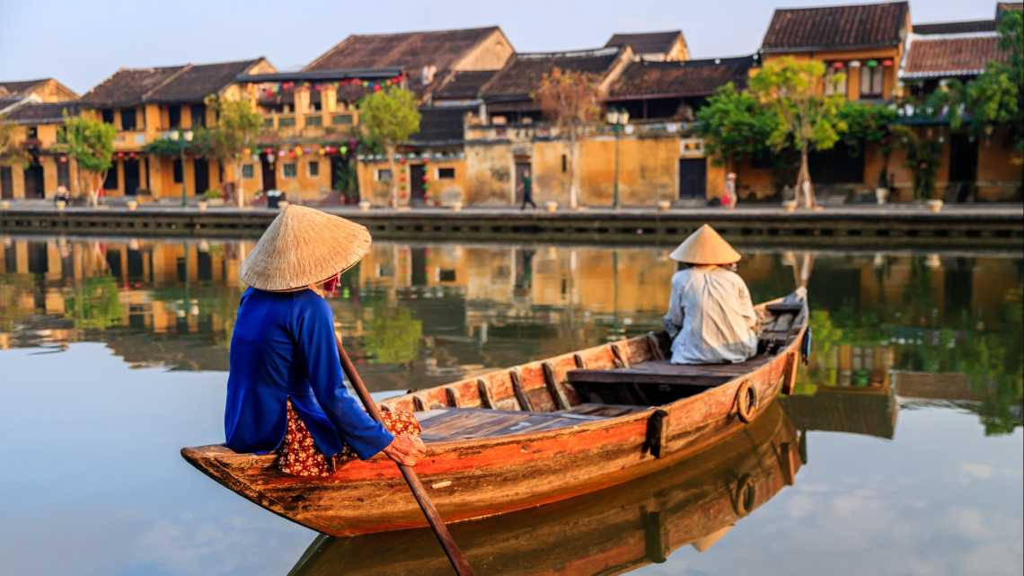 Vietnamesische Frauen paddeln in der Altstadt der Stadt Hoi An, Vietnam.
