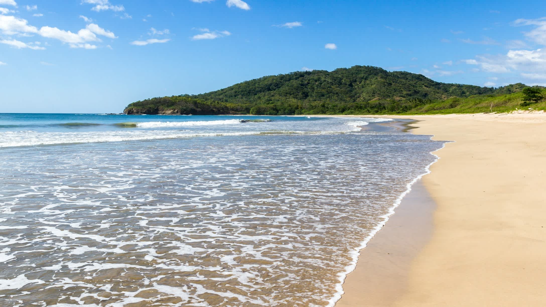 Scène de plage tranquille avec une longue plage de sable vide à Playa Ventanas, Costa Rica