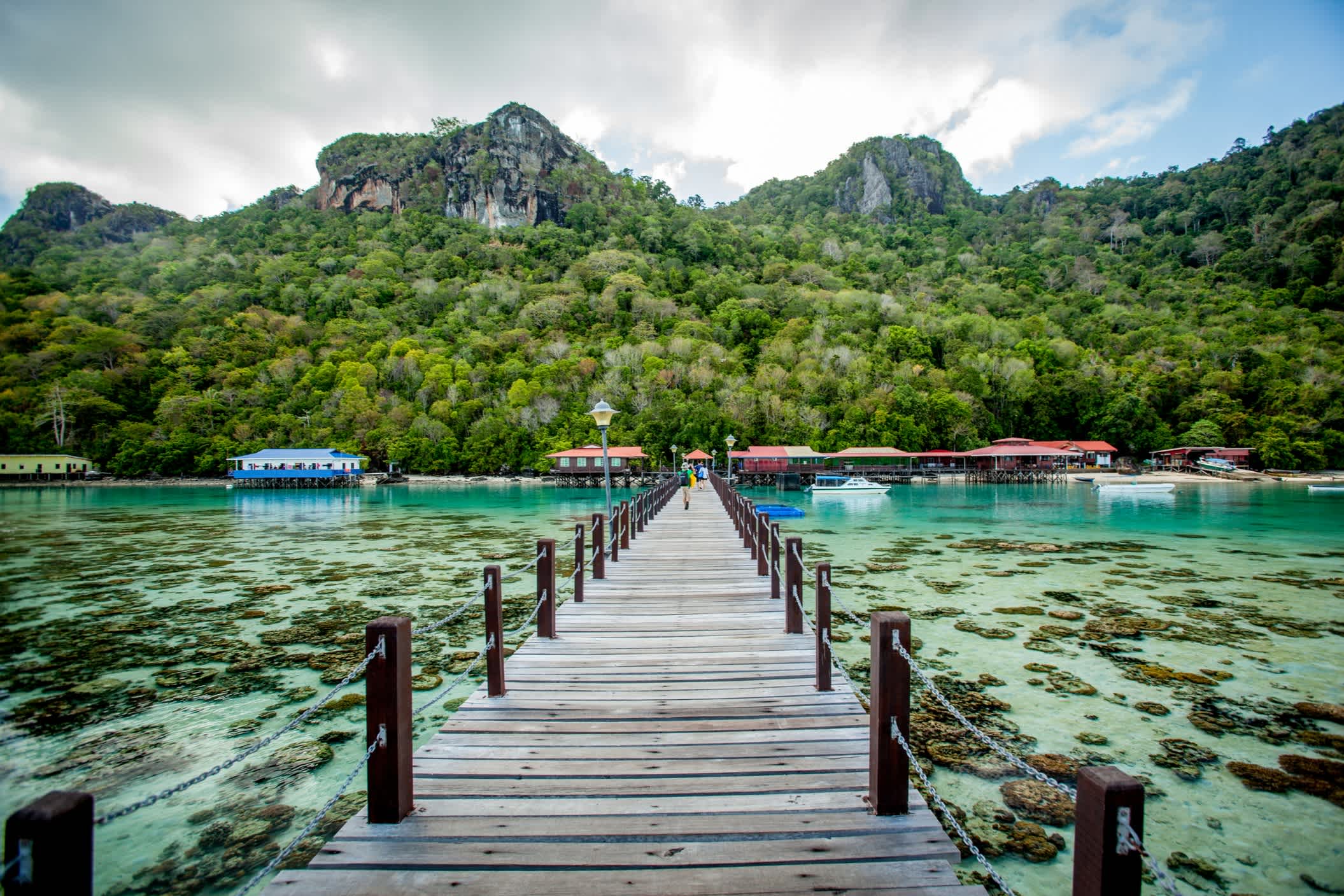 Holzbrücke über türkisblauem Wasser in Borneo.