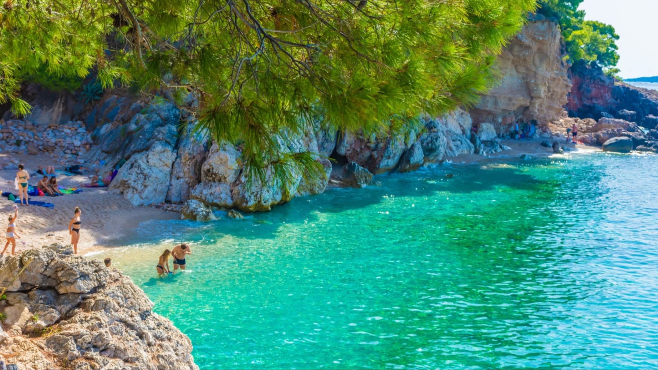 Der Jagodna Bay, Insel Hvar, Kroatien mit Blick auf das grüne klare Wasser, Felsenwände und Menschen am Strand.
