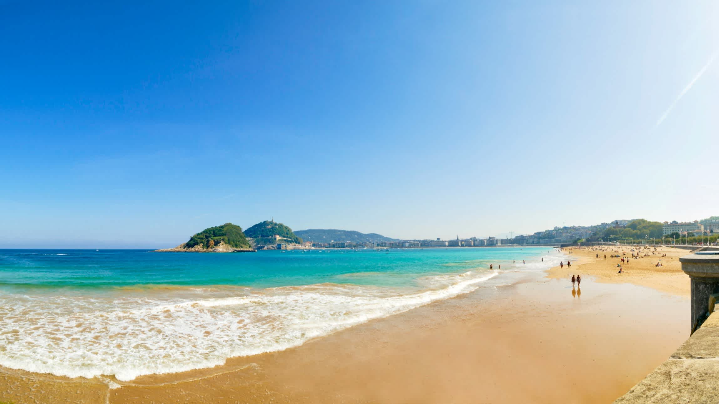 Personnes sur la magnifique plage de sable au bord d'une mer turquoise en Espagne