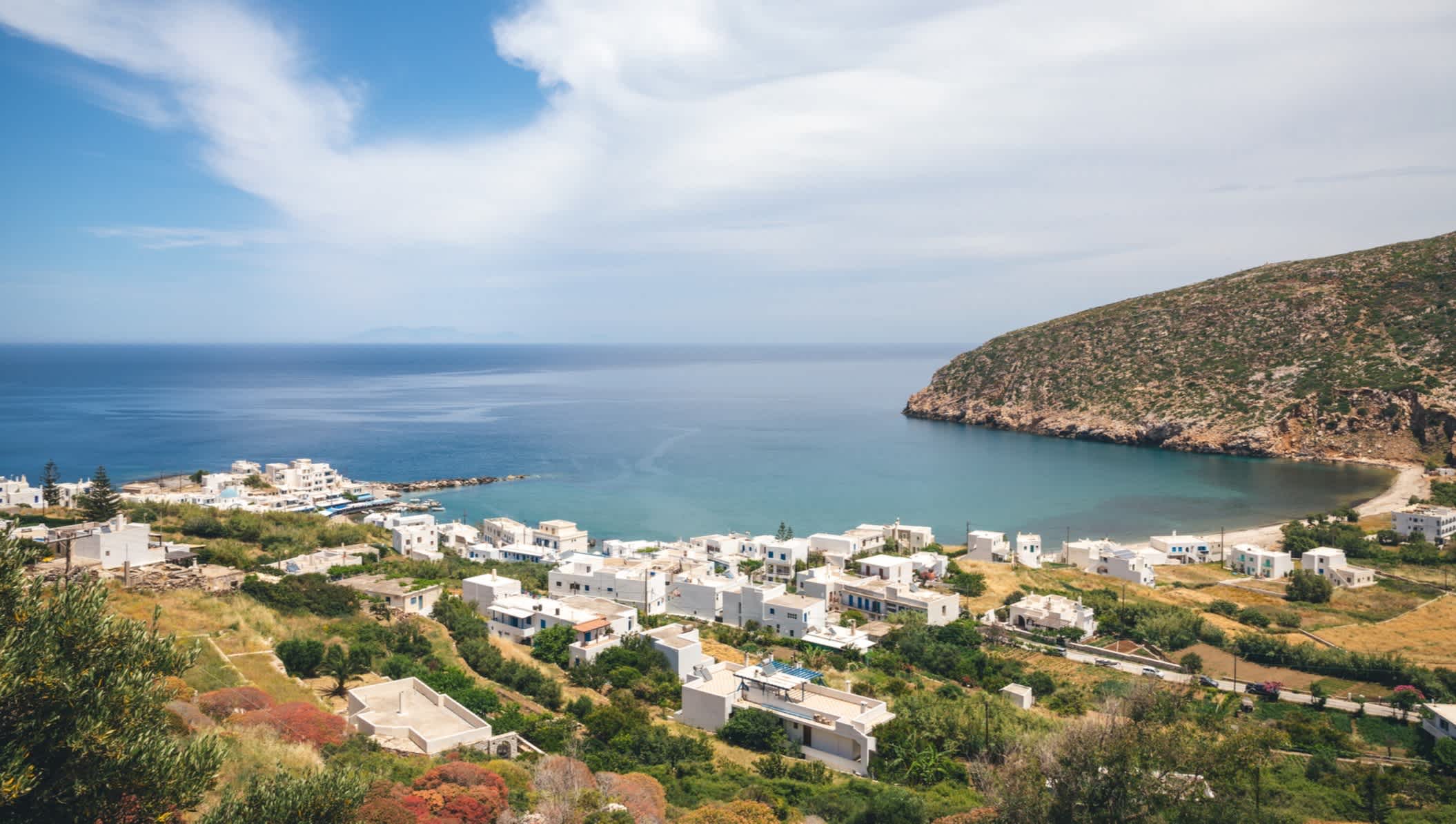 Blick auf die Stadt Apollonas auf Naxos, Griechenland, mit dem türkisblauen Meer und der Apollonas Bucht im Hintergrund.