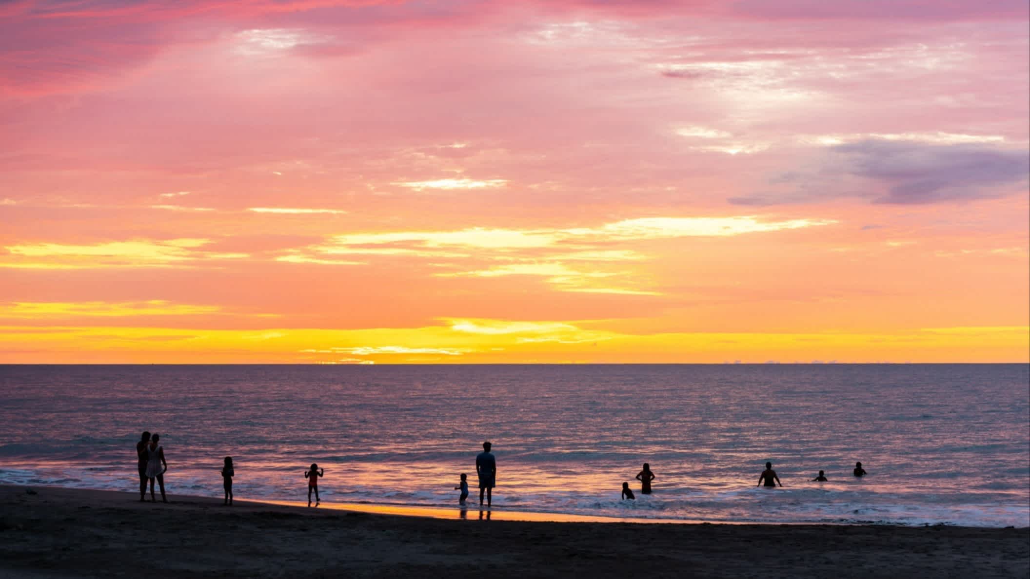 Menschen schauen sich den Sonnenuntergang am Strand von Same, Provinz Esmeraldas, Ecuador an.