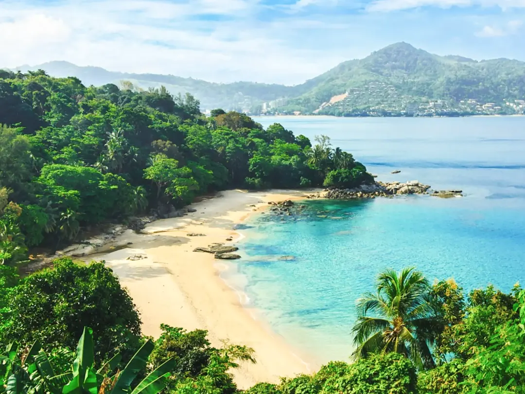 Versteckter Sandstrand mit türkisfarbenem Wasser und grünen Hügeln. Laem Singh, Kathu, Phuket, Thailand.