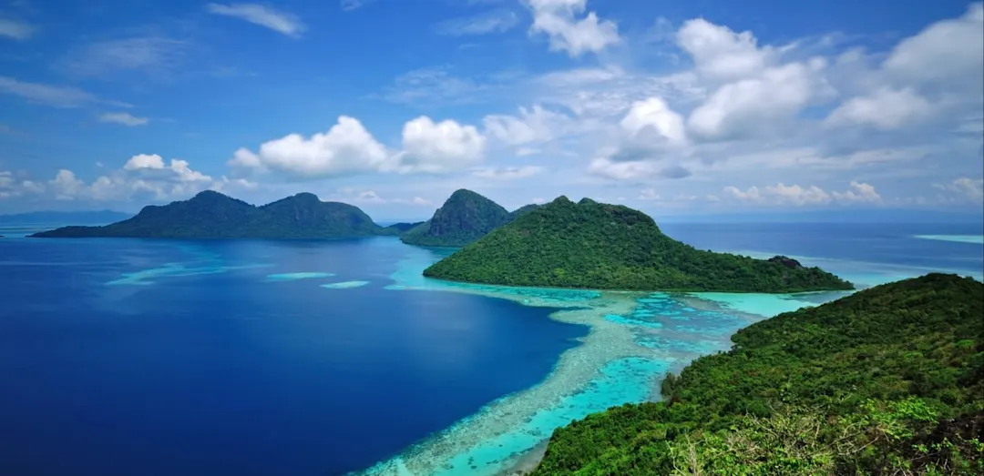 Tropische Inseln mit türkisfarbenem Wasser und Korallen, Semporna, Sabah, Malaysia.