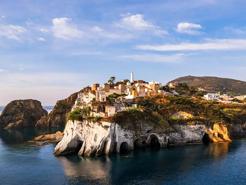 Italien, Latium, Ponza Malerische Klippen mit kleinen Häusern und Leuchtturm. Ponza Insel, Latium, Italien.