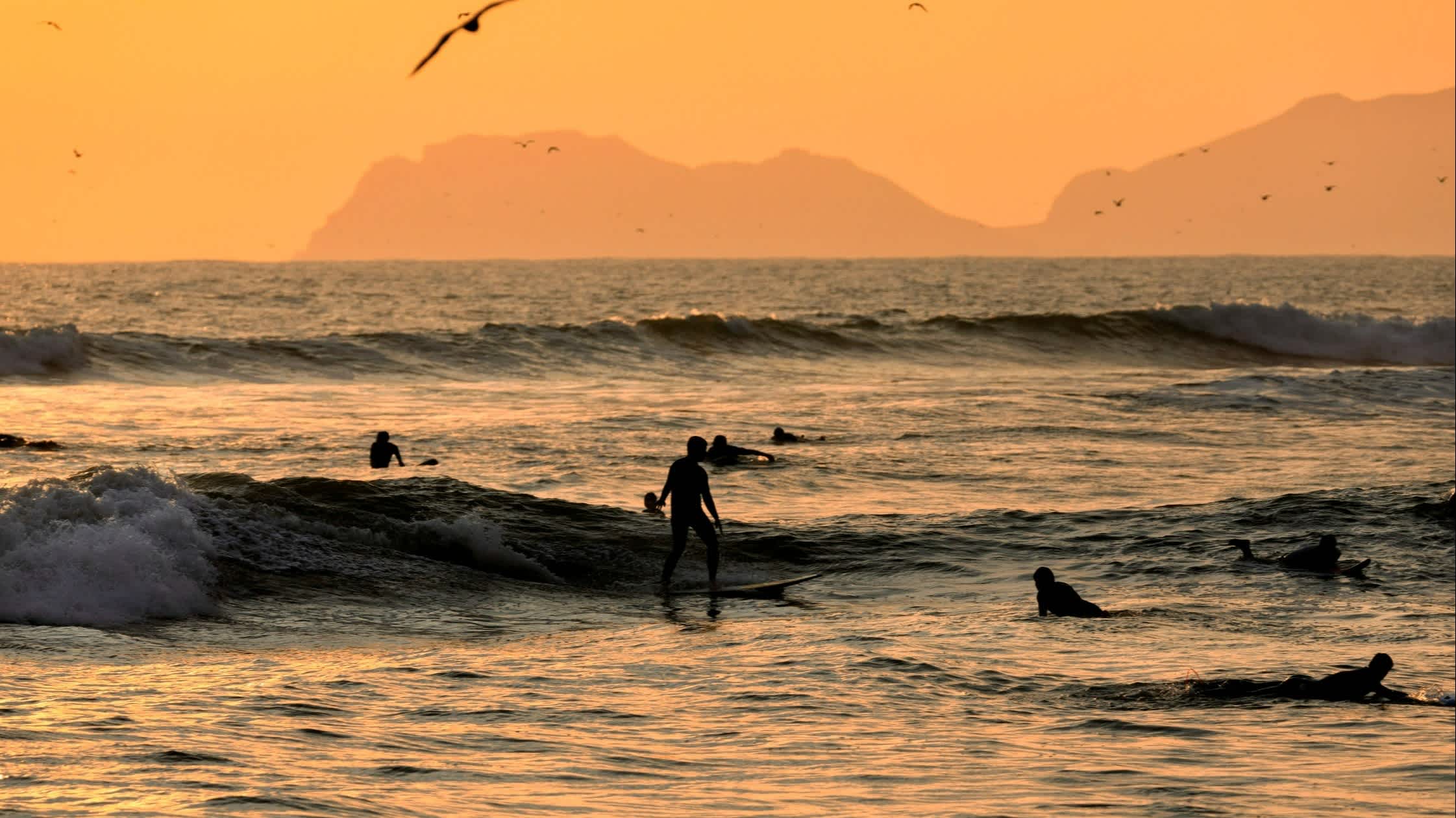 Surfer im Wasser bei Sonnenuntergang