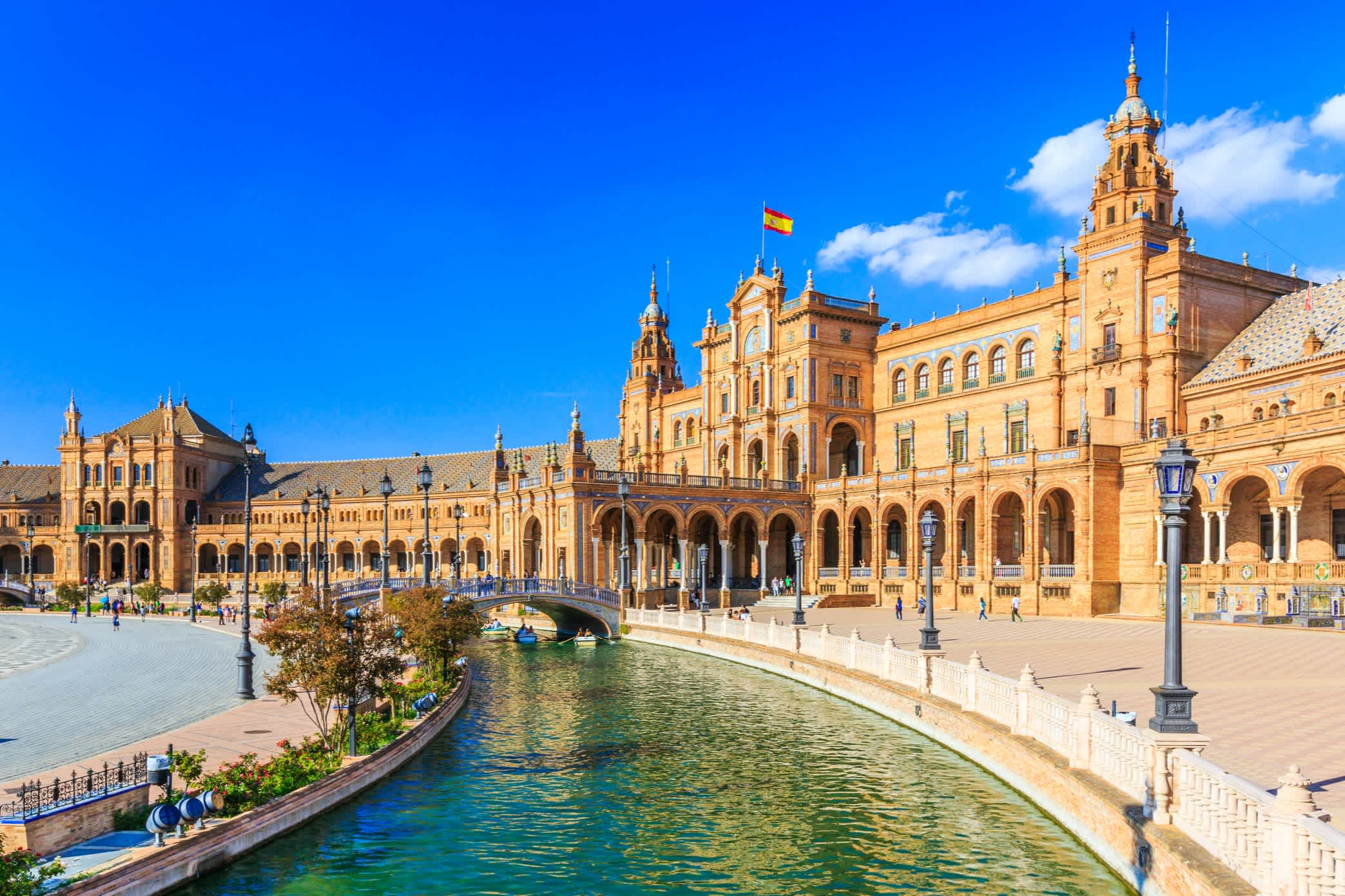 Bâtiment historique à Séville, Espagne, avec canal et pont.