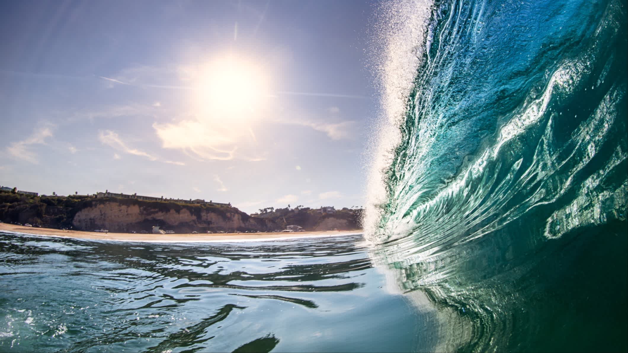 Eine Welle bricht bei herrlichem Sonnenschein am Strand Zuma Beach, Malibu, Kalifornien, USA.